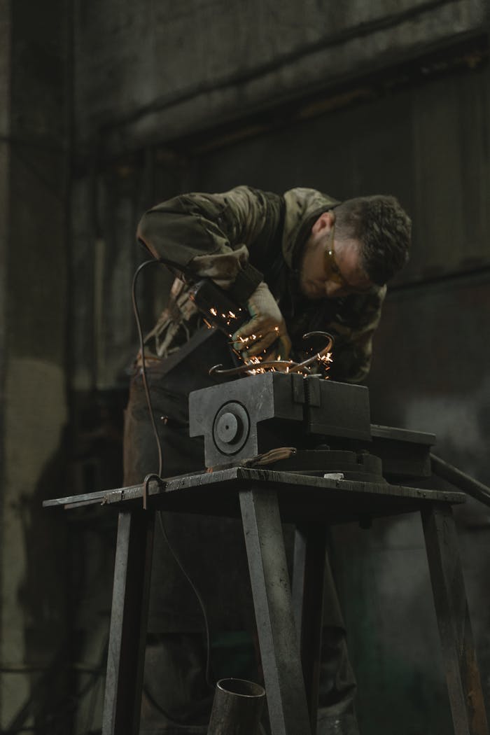 Metalworker grinding metal, creating sparks in an industrial setting